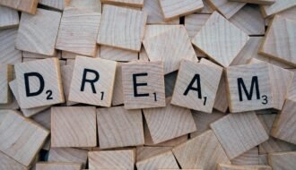 Close-up of wooden Scrabble tiles spelling the word 'DREAM', symbolizing creativity and imagination.