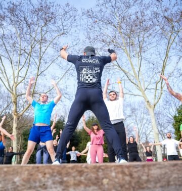 Group exercise session in a sunny Istanbul park led by a fitness coach outdoors.
