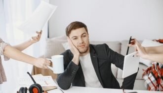 A businessman overwhelmed by tasks in a modern office setting, depicting multitasking and stress.